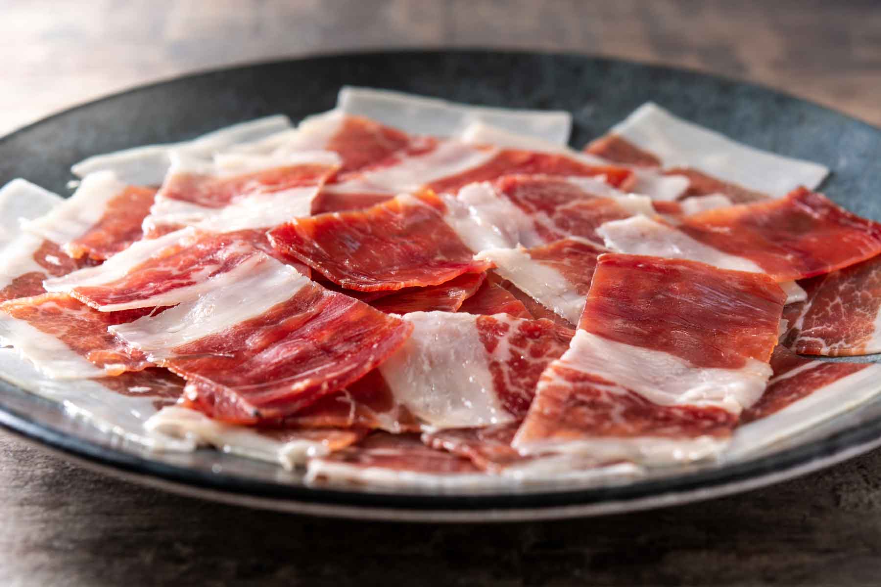 plato con lonchas de jamón serrano en plano corto 